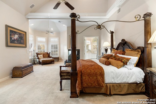 carpeted bedroom with a high ceiling, ornamental molding, ensuite bath, and ceiling fan