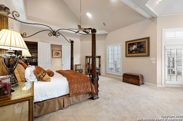 bedroom featuring light carpet and high vaulted ceiling