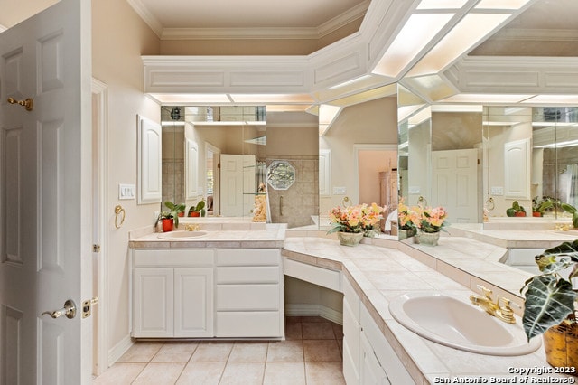 bathroom featuring tile floors, vanity with extensive cabinet space, and ornamental molding