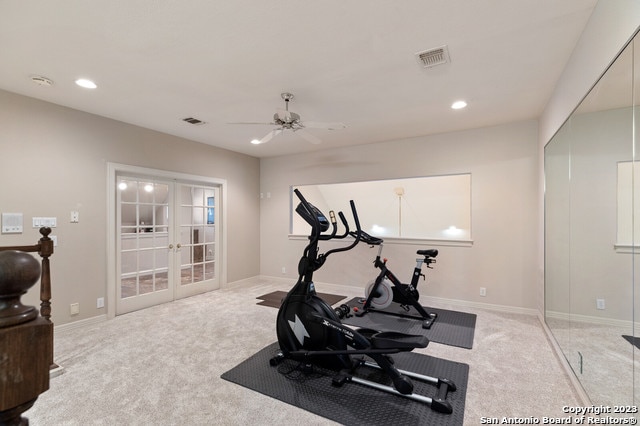 exercise room with light colored carpet, ceiling fan, and french doors