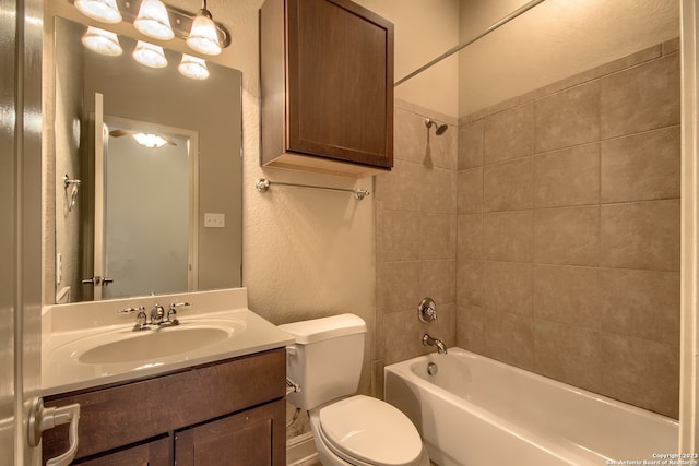 full bathroom with toilet, tiled shower / bath combo, and vanity