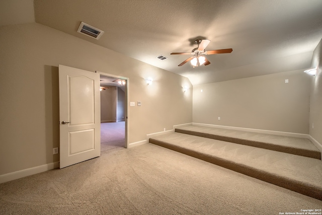 carpeted spare room featuring ceiling fan and vaulted ceiling