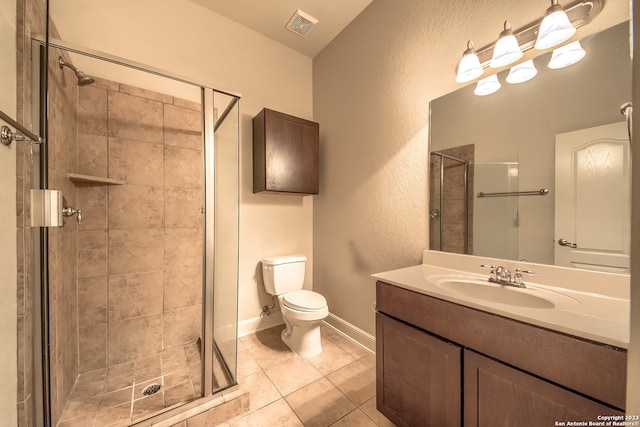 bathroom with tile flooring, large vanity, toilet, and a shower with shower door