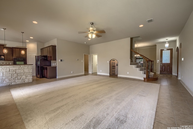 unfurnished living room featuring ceiling fan and light tile flooring