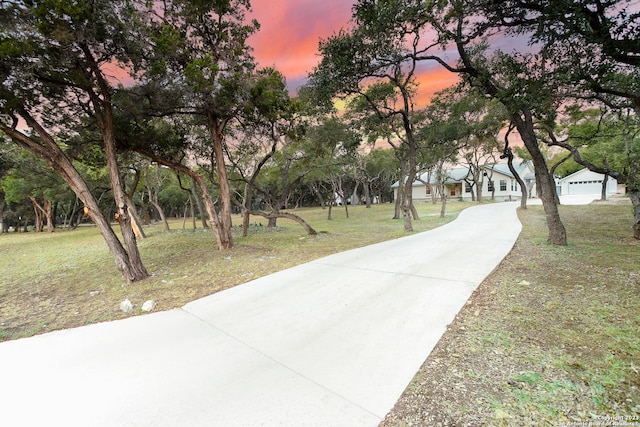 view of property's community featuring a lawn and a garage