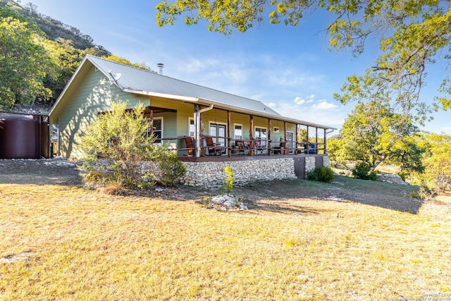 rear view of house with a porch and a lawn