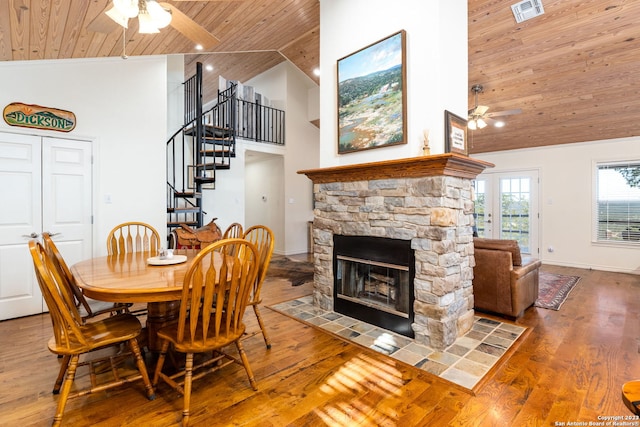 dining area with wood ceiling, a fireplace, hardwood / wood-style flooring, high vaulted ceiling, and ceiling fan