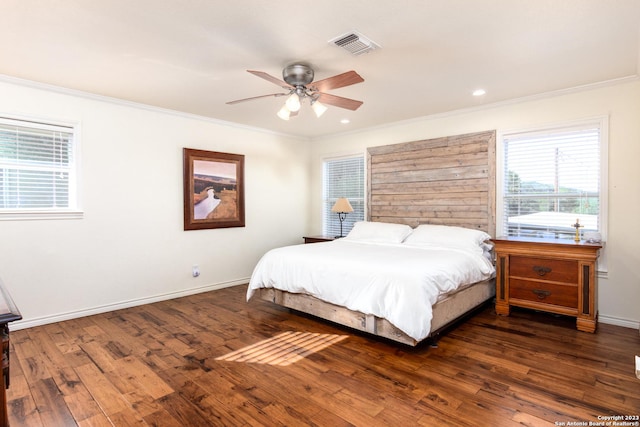 bedroom with ceiling fan, ornamental molding, and dark wood-type flooring