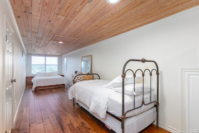 bedroom with ornamental molding, dark hardwood / wood-style flooring, and wood ceiling