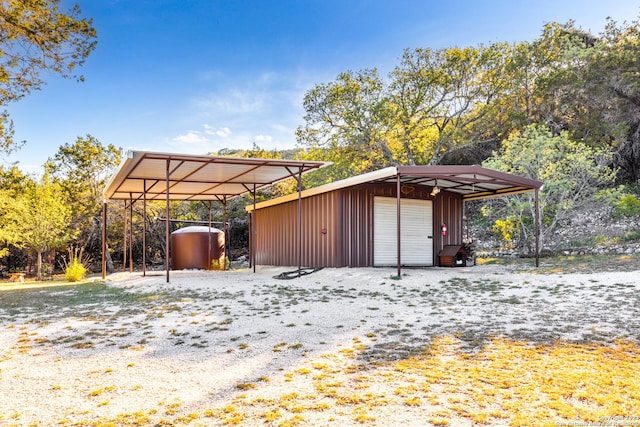 view of outdoor structure with a garage and a carport