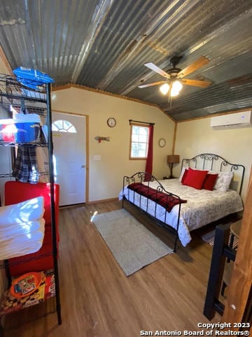 bedroom with dark hardwood / wood-style floors, ceiling fan, and a wall unit AC