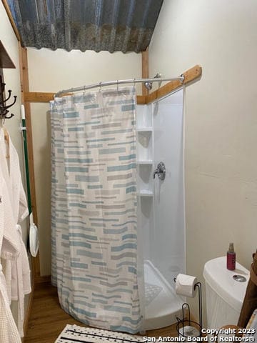 bathroom with walk in shower and wood-type flooring