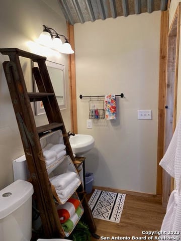 bathroom featuring hardwood / wood-style floors and toilet