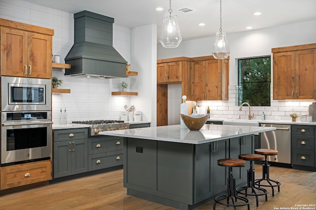 kitchen with tasteful backsplash, a kitchen island, stainless steel appliances, gray cabinets, and premium range hood