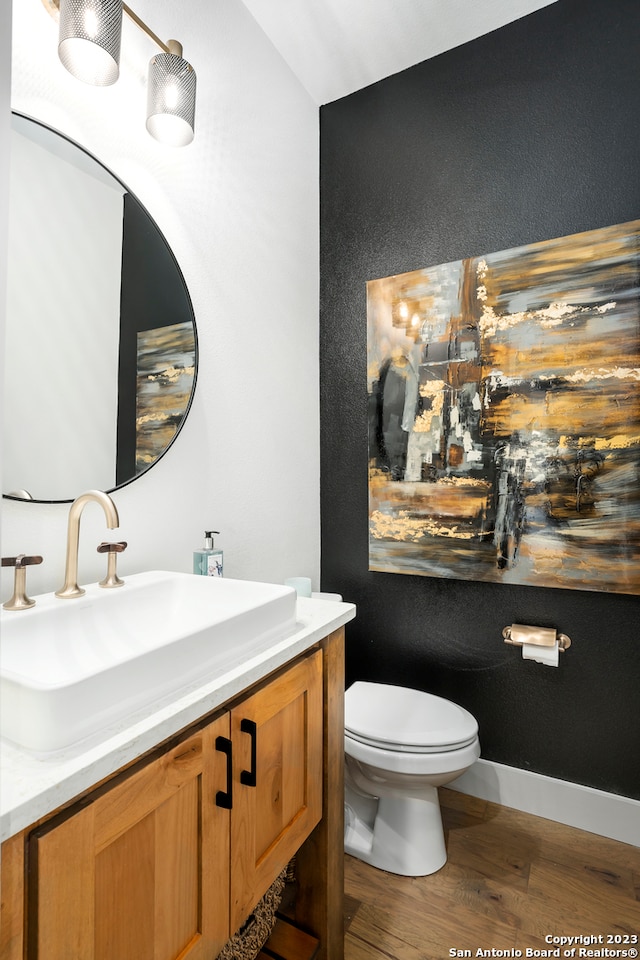 bathroom featuring vanity, toilet, and hardwood / wood-style flooring