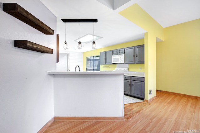 kitchen featuring hanging light fixtures, light wood-type flooring, gray cabinetry, sink, and kitchen peninsula