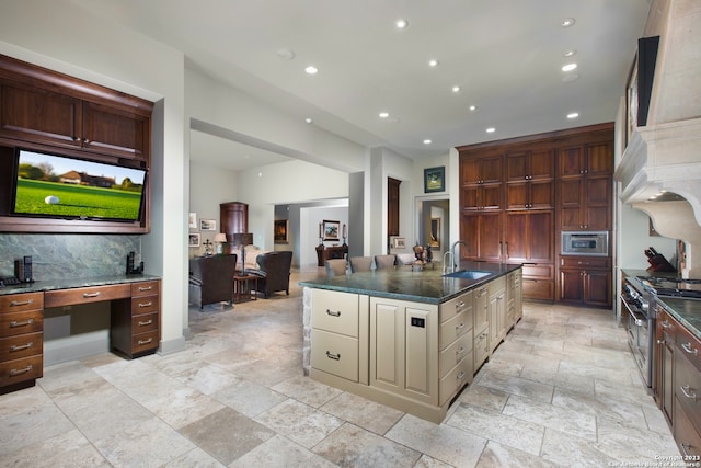 kitchen with a center island with sink, light tile flooring, sink, and stainless steel range