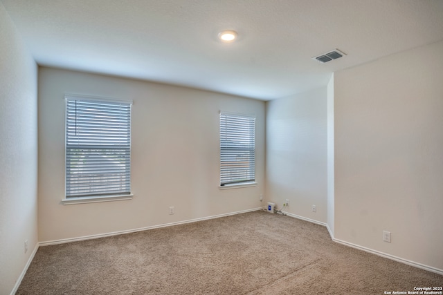 spare room featuring light colored carpet