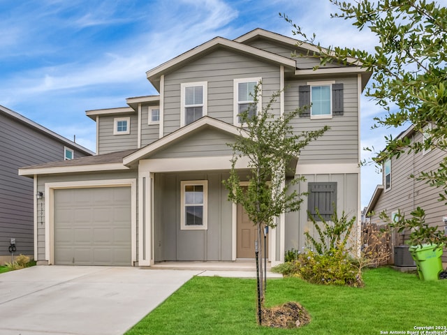 view of front of home featuring a front yard, central AC unit, and a garage