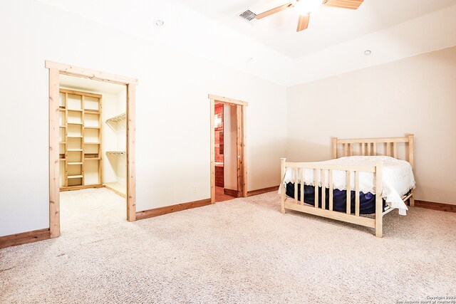 carpeted bedroom featuring ceiling fan, a spacious closet, and a closet