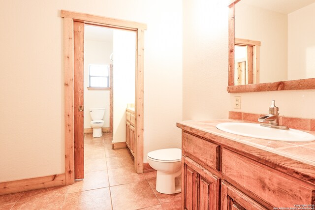 bathroom with vanity, tile flooring, and toilet