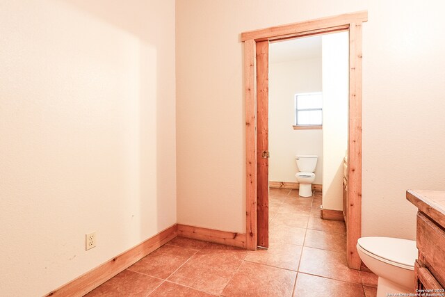 bathroom with tile floors, toilet, and vanity