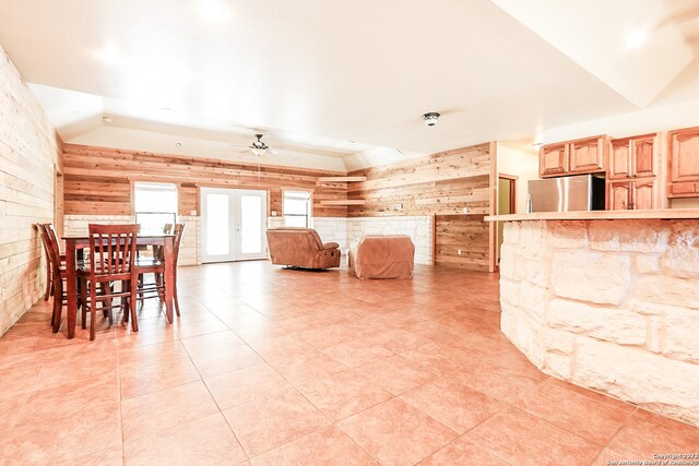 interior space featuring french doors, wood walls, and ceiling fan