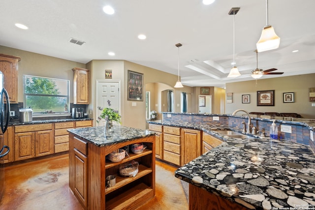 kitchen featuring a kitchen island, hanging light fixtures, ceiling fan, and sink