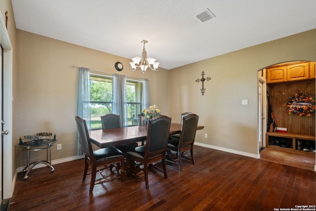 dining room with an inviting chandelier and dark hardwood / wood-style flooring