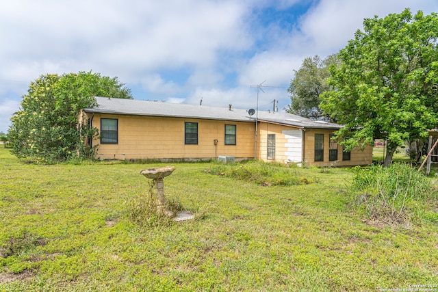 rear view of house featuring a yard