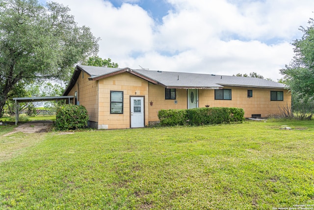 rear view of house featuring a lawn and a carport