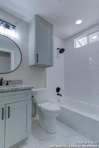 full bathroom with vanity, tile flooring, toilet, and tiled shower / bath