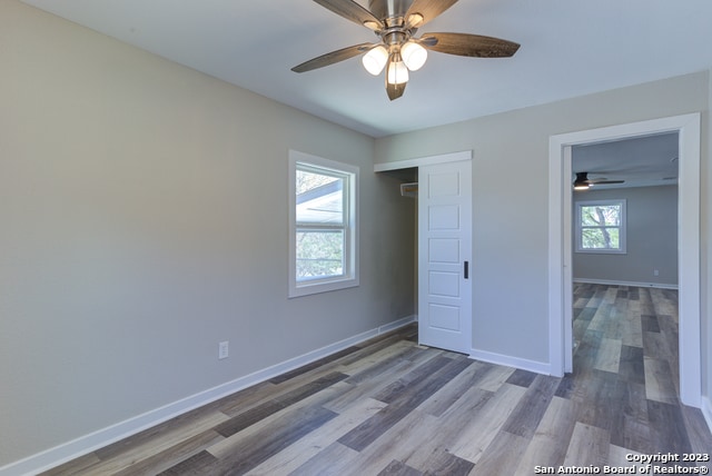 unfurnished bedroom featuring dark hardwood / wood-style flooring, a closet, and ceiling fan