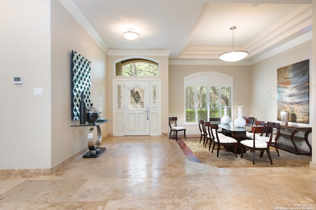 foyer featuring tile patterned flooring, a raised ceiling, and crown molding