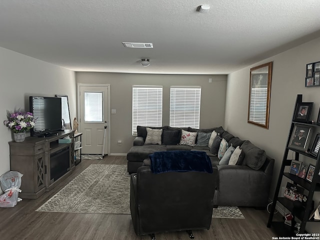 living room with dark hardwood / wood-style floors and a textured ceiling