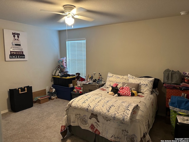 carpeted bedroom with ceiling fan and a textured ceiling