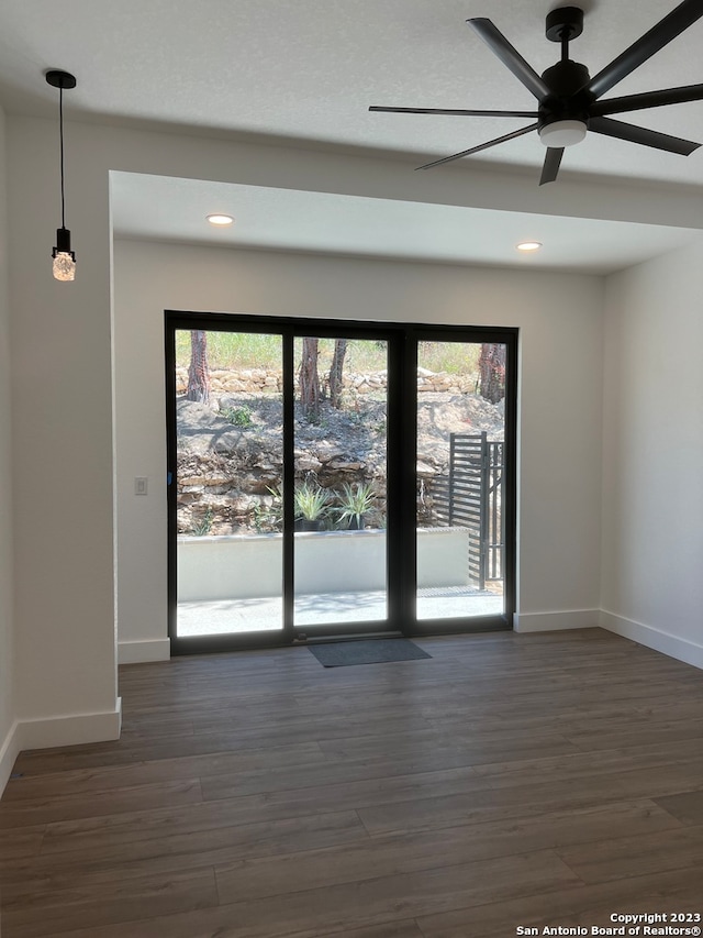 unfurnished room featuring dark hardwood / wood-style flooring, ceiling fan, and a wealth of natural light