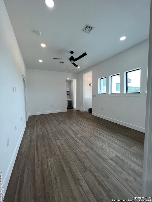 empty room with ceiling fan and dark wood-type flooring