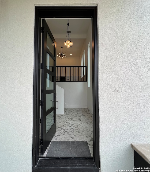 corridor with an inviting chandelier