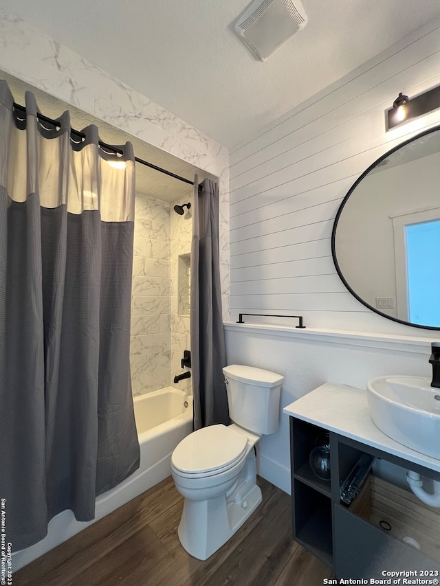 full bathroom featuring shower / bath combo, a textured ceiling, toilet, oversized vanity, and hardwood / wood-style flooring