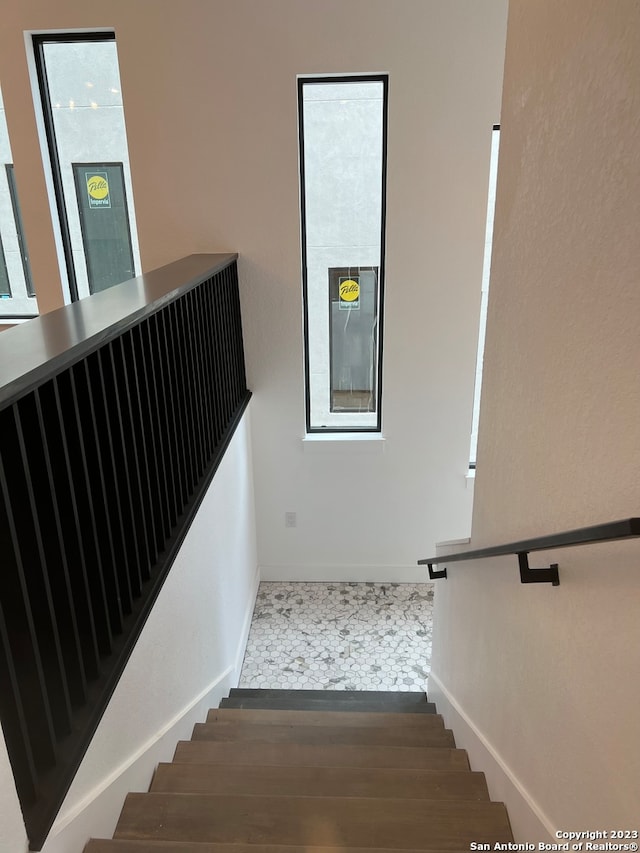 stairs featuring dark tile flooring