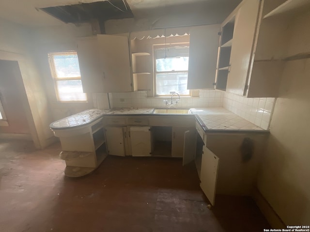 kitchen featuring tile countertops, sink, and tasteful backsplash