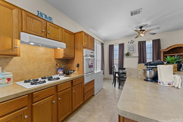 kitchen with light tile floors, ceiling fan, white appliances, and a textured ceiling