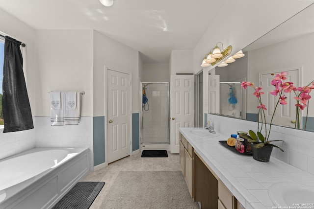 bathroom with dual vanity, tile floors, and separate shower and tub