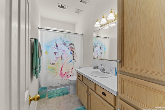 bathroom featuring toilet, tile flooring, and vanity