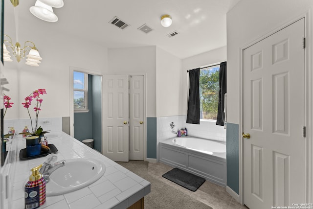 bathroom with tile flooring, a bathing tub, and vanity