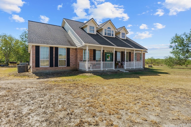 cape cod house featuring central AC, a front lawn, and covered porch