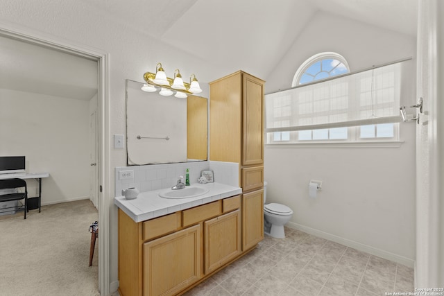 bathroom featuring toilet, large vanity, vaulted ceiling, backsplash, and tile floors