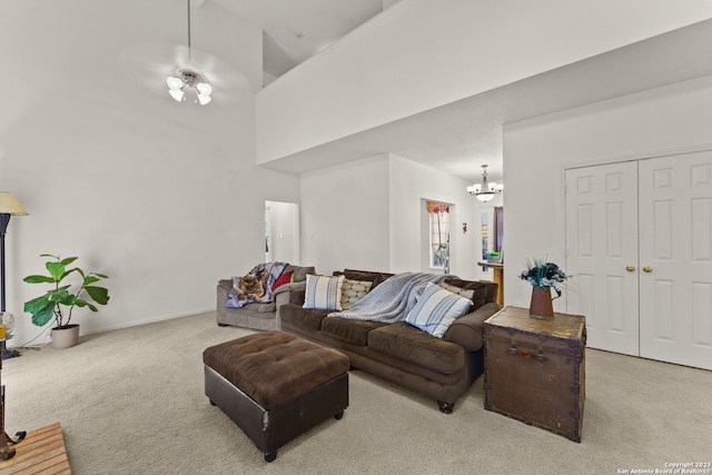 living room featuring high vaulted ceiling, light colored carpet, and ceiling fan with notable chandelier