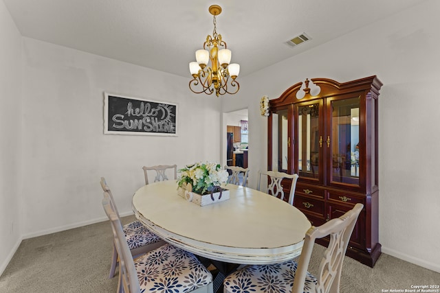 carpeted dining area with an inviting chandelier